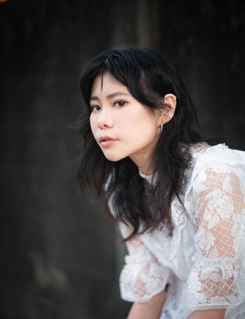 Close portrait of Aey Kuljira Thongkong in a white lace dress.