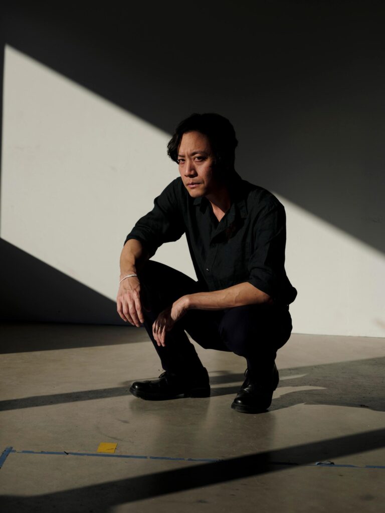 Chol Janepraphaphan crouching in a patch of sunlight inside a Chiang Mai gallery.
