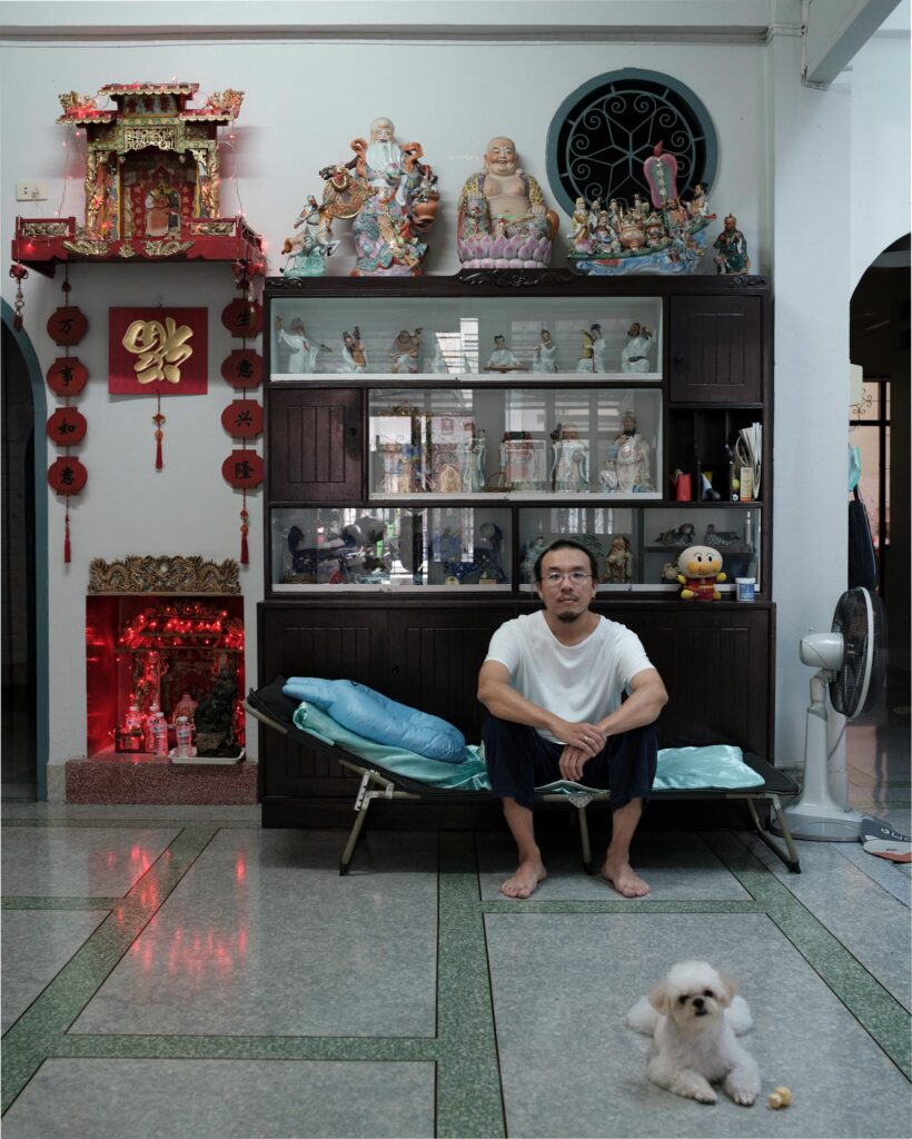 Jay Vatanakuljaras seated in his Bangkok family home with a small dog on the floor.