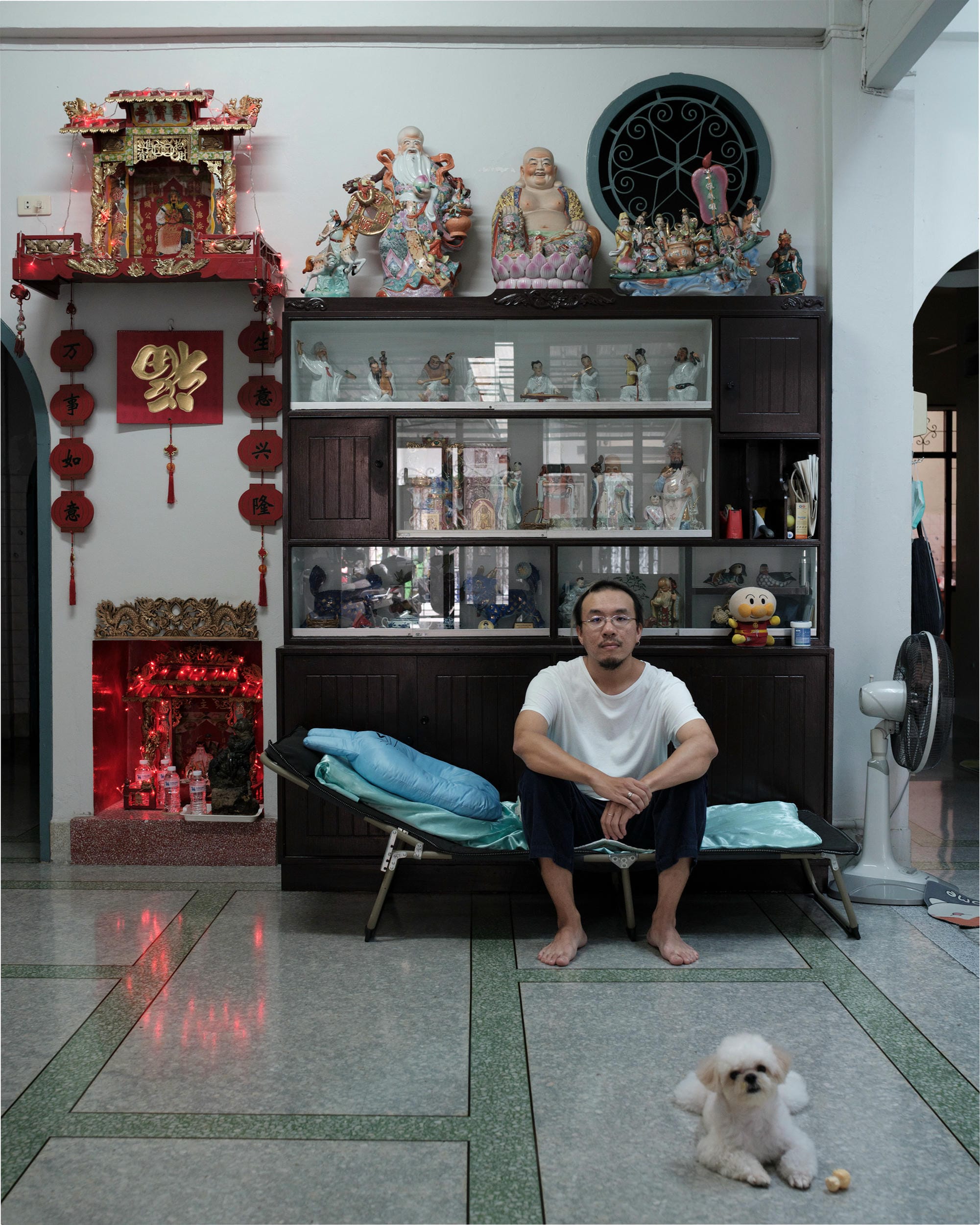 Jay Vatanakuljaras seated in his Bangkok family home with a small dog on the floor.
