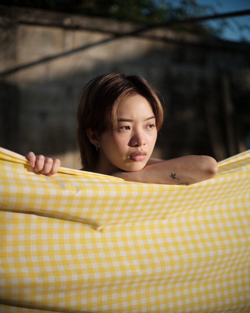 Kim holding yellow gingham fabric in front of her