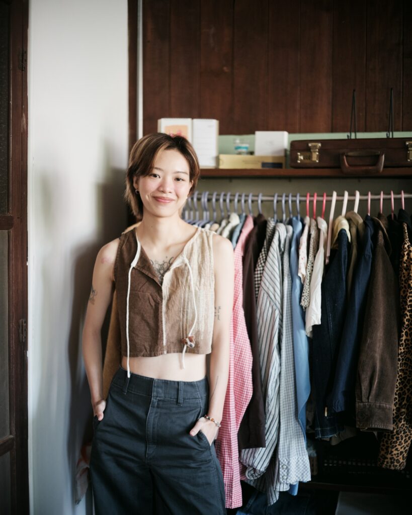 Kim standing beside a rack of clothes