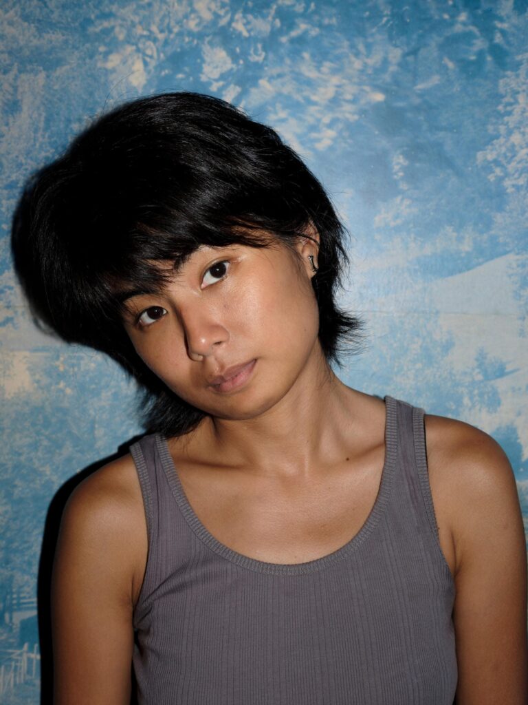 Close portrait of MM.Kosum against a mottled blue background.