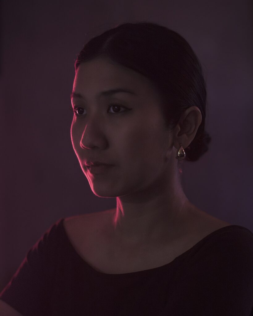 Portrait of Pokchat in low light with a pink glow
