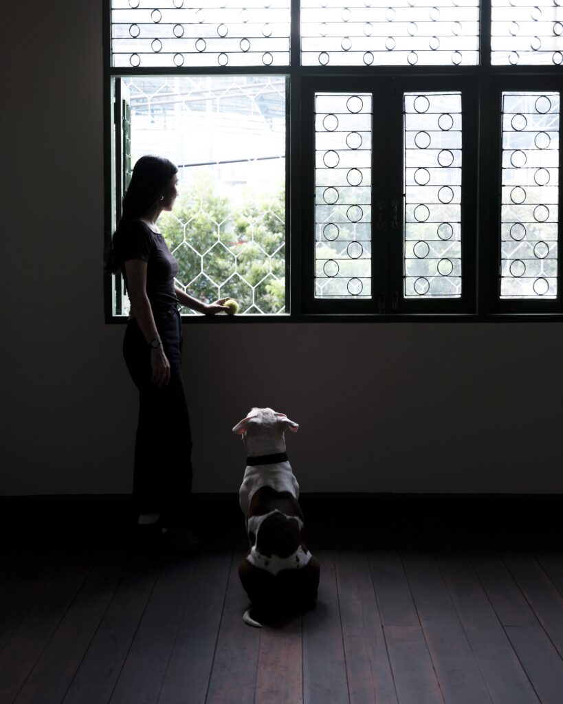 Pokchat and her dog beside a large studio window
