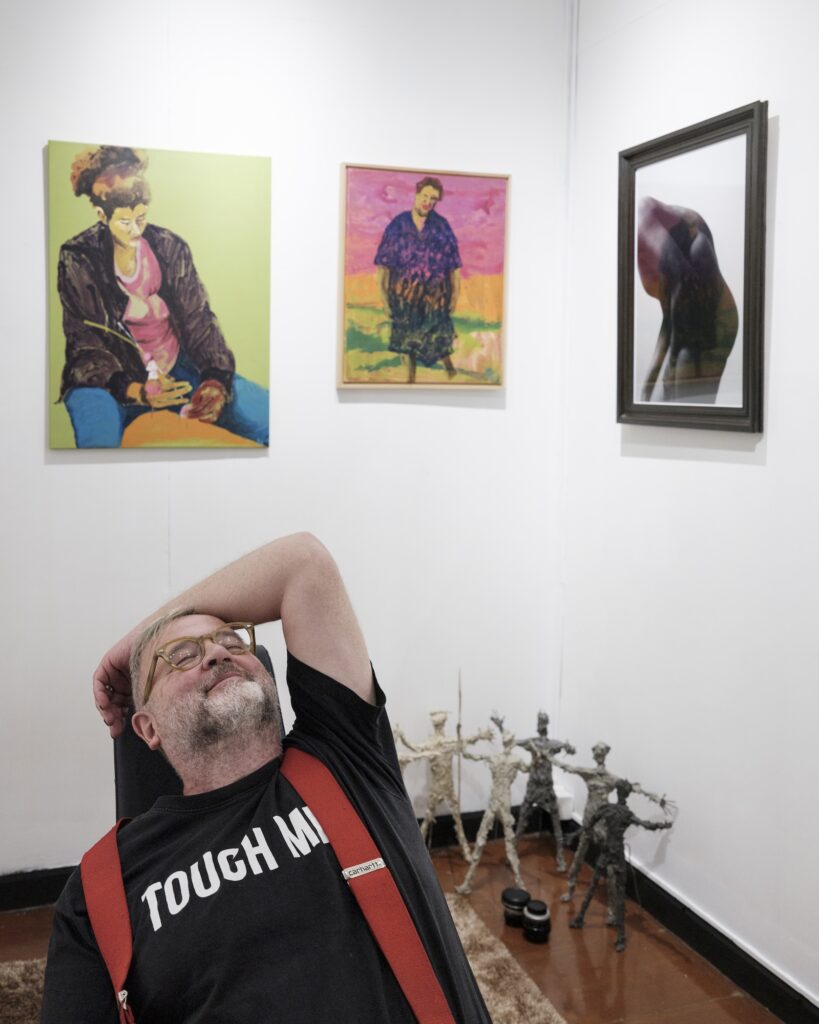 Reinhard reclining with one arm behind his head in an art gallery