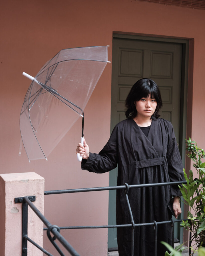 Rung holding a bent transparent umbrella on a balcony
