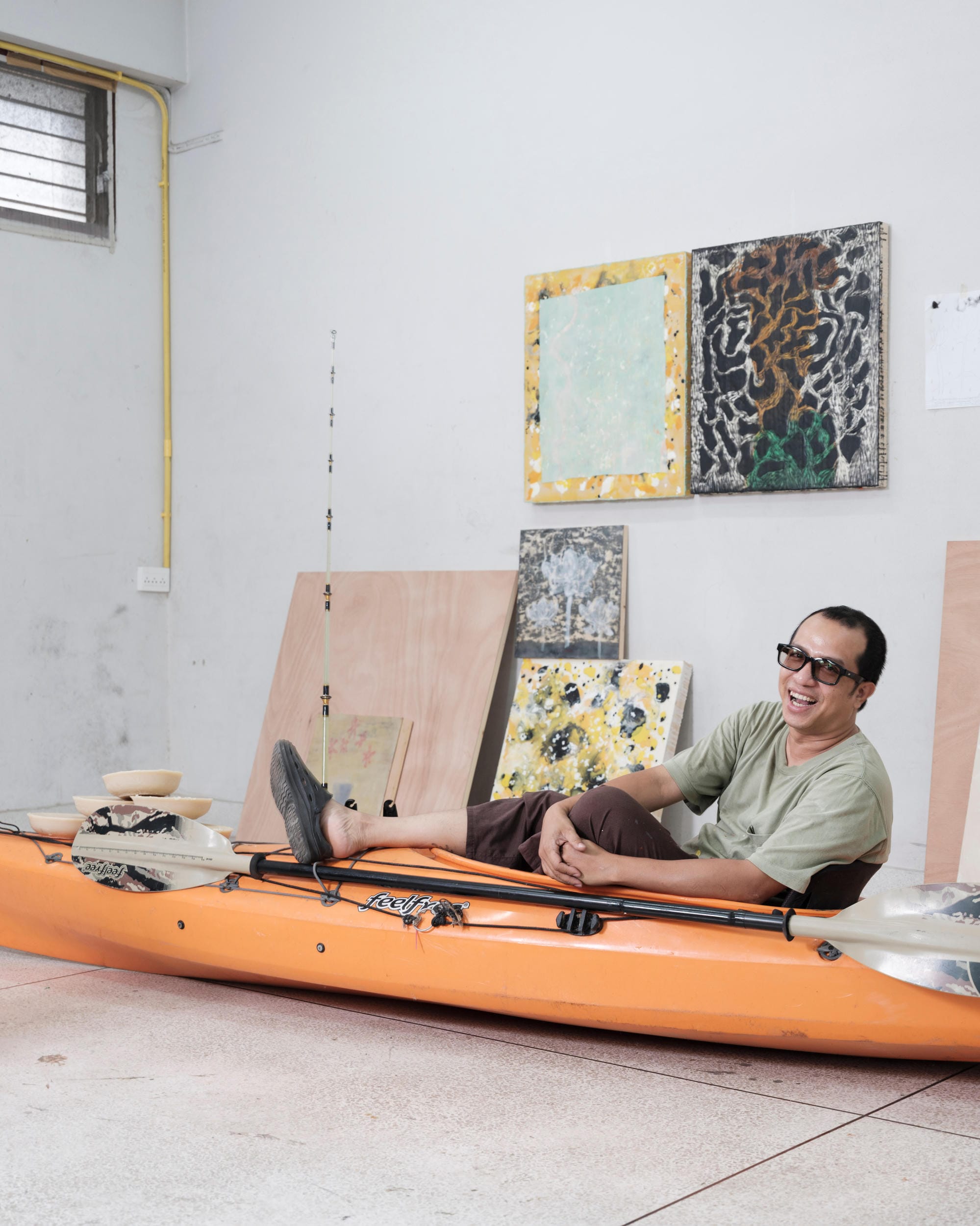 Tada Hengsapkul sitting in an orange kayak inside his Bangkok studio.
