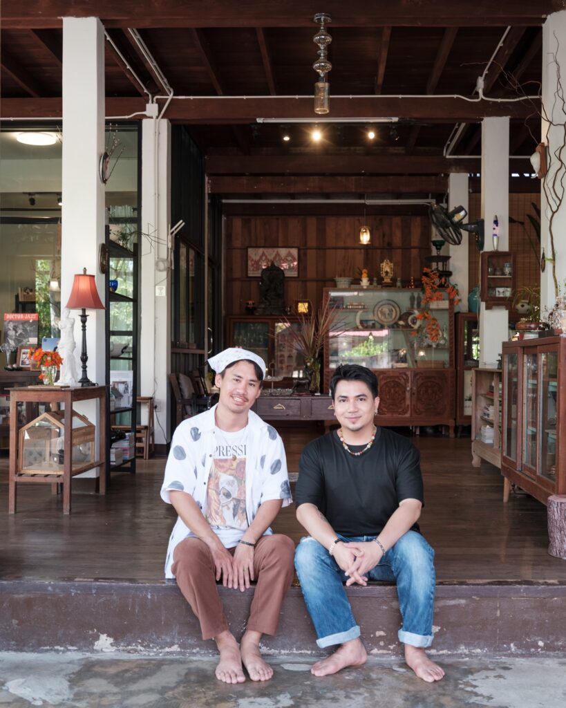 Tul and Em seated together on the front step of their wooden house