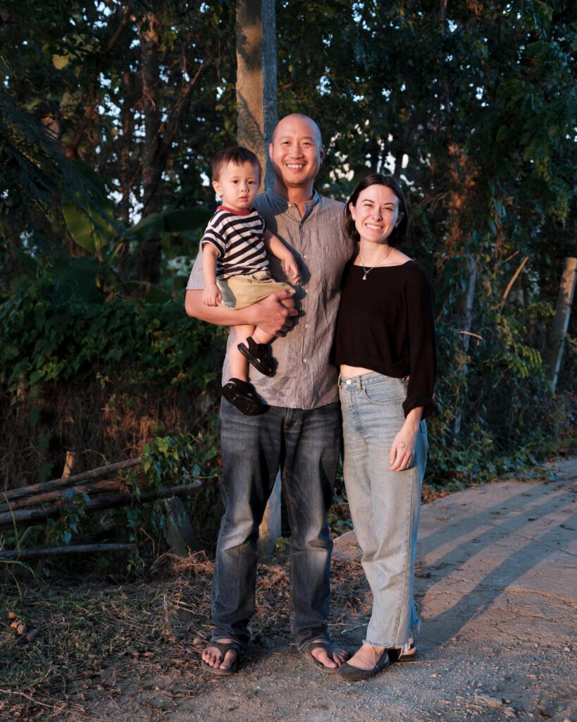 Alex Wang holding a child beside a woman on a path near Phayao.