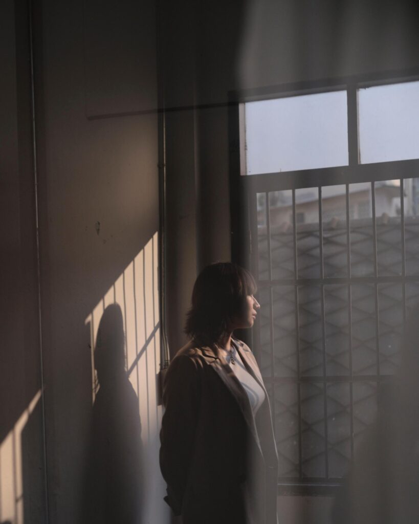 Member of Zua, Cinema and Chalan lit by sunlight beside a window in Bangkok.