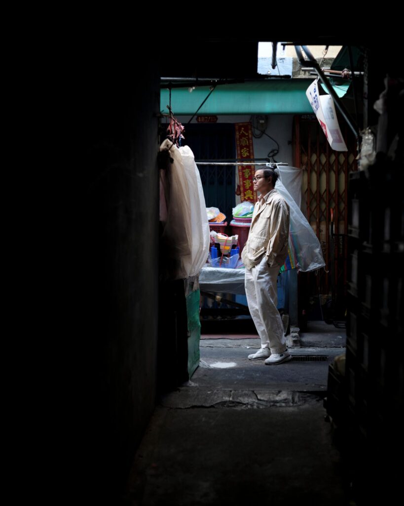 Member of Zua, Cinema and Chalan standing in a narrow Bangkok alley.
