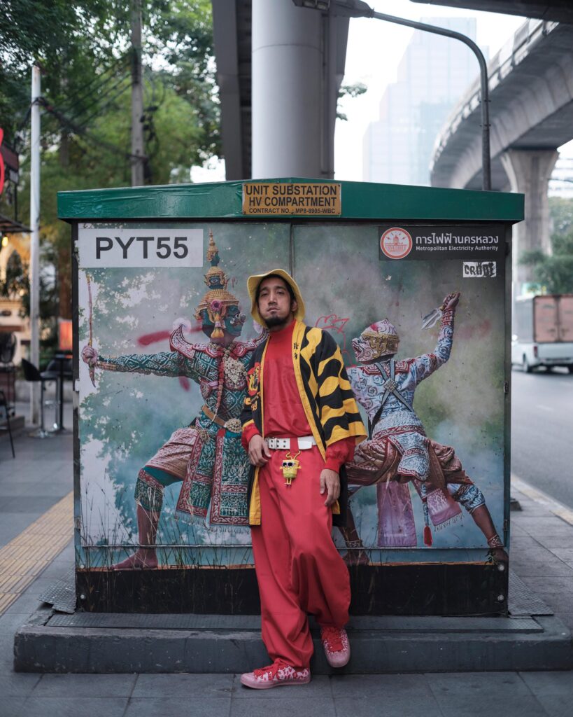 Banana Freeman standing in front of a painted utility box in Bangkok.