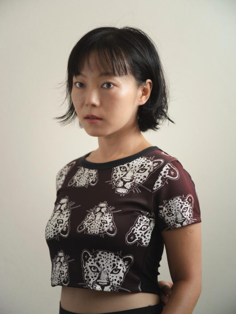 Portrait of Chun Li wearing a dark patterned top at home in Bangkok.