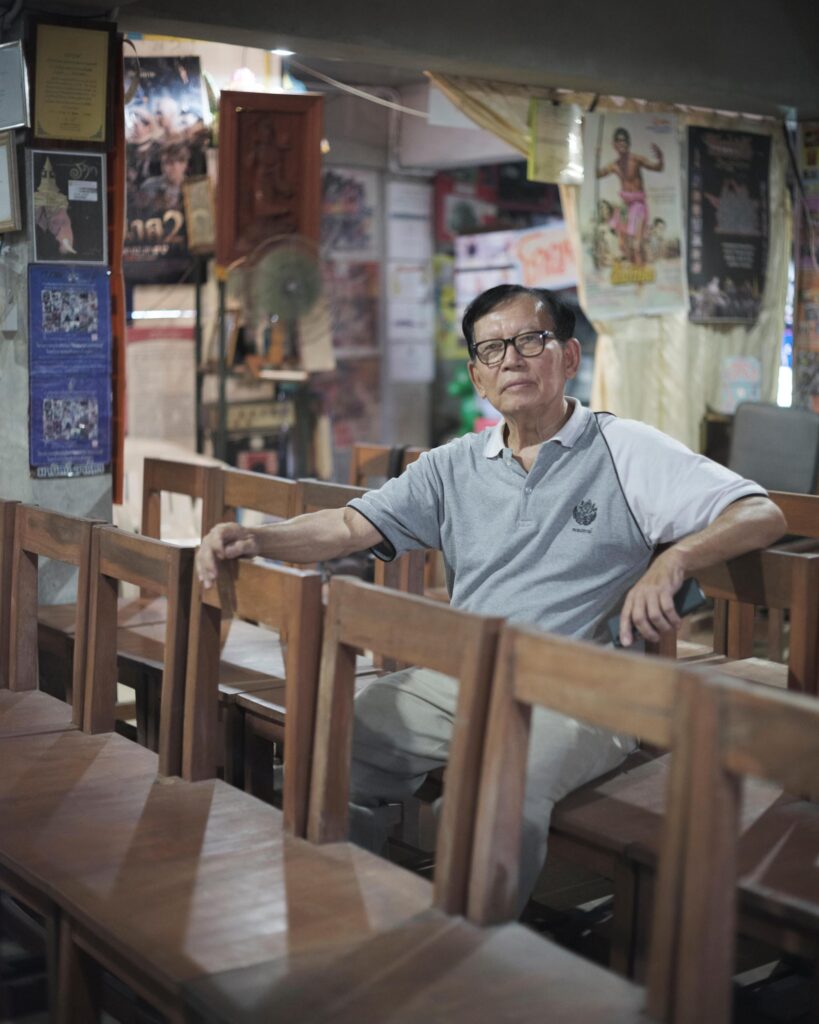 Manit Worachat seated among wooden cinema benches in his Lampang museum.