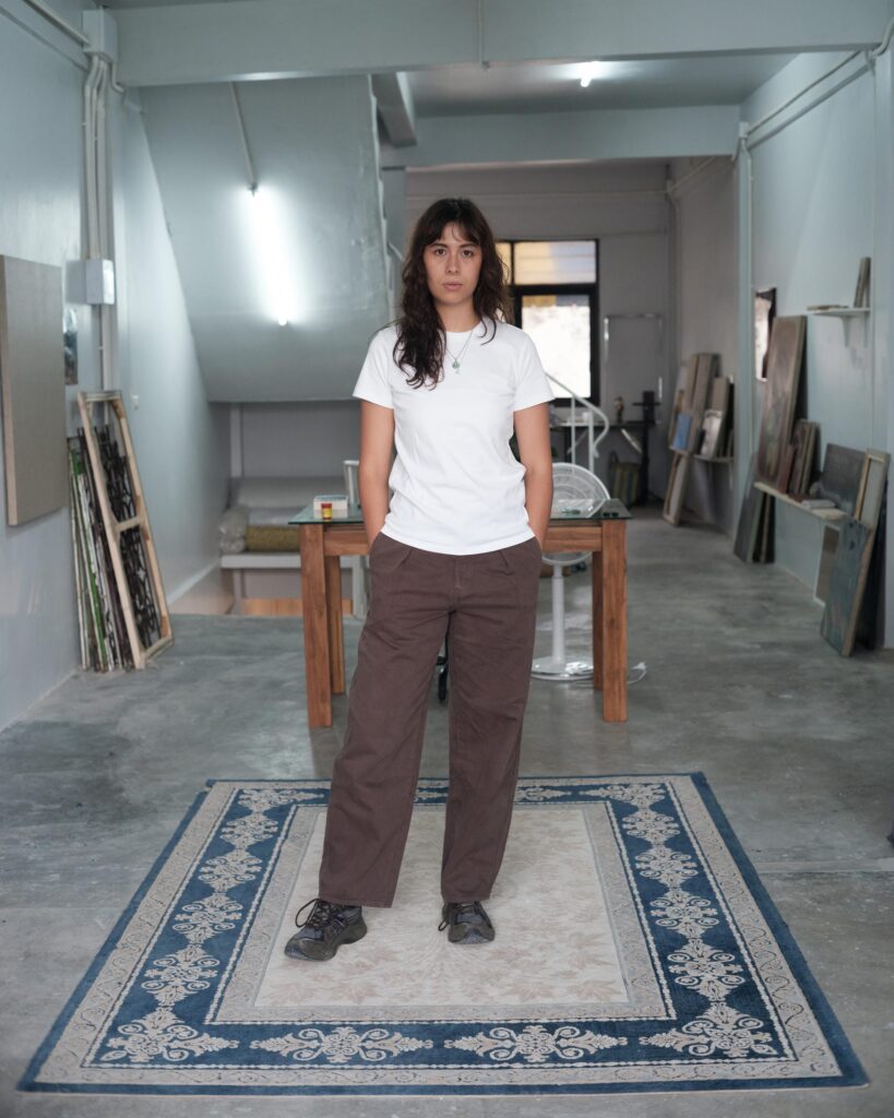 Natalie Sasi Organ standing on a patterned rug in her Bangkok studio.