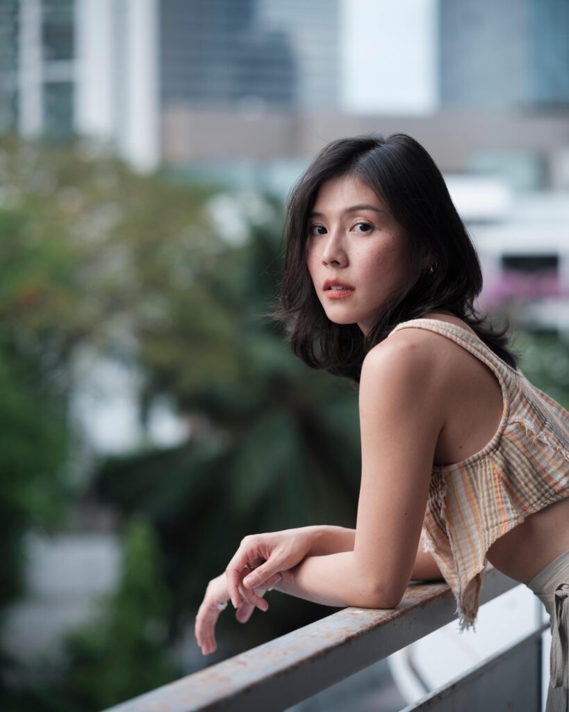 Pahparn Sirima leaning on a balcony railing in Bangkok.