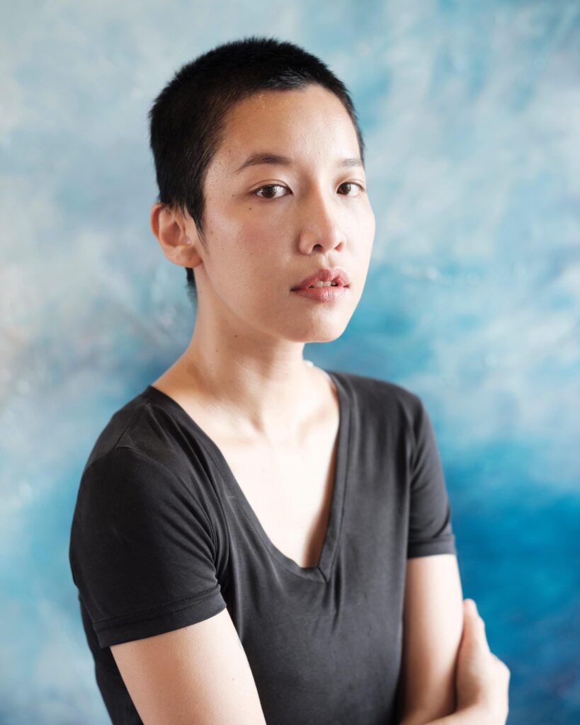 Pare Patcharapa Inchang in front of a blue-and-white painting in her Chiang Mai studio.