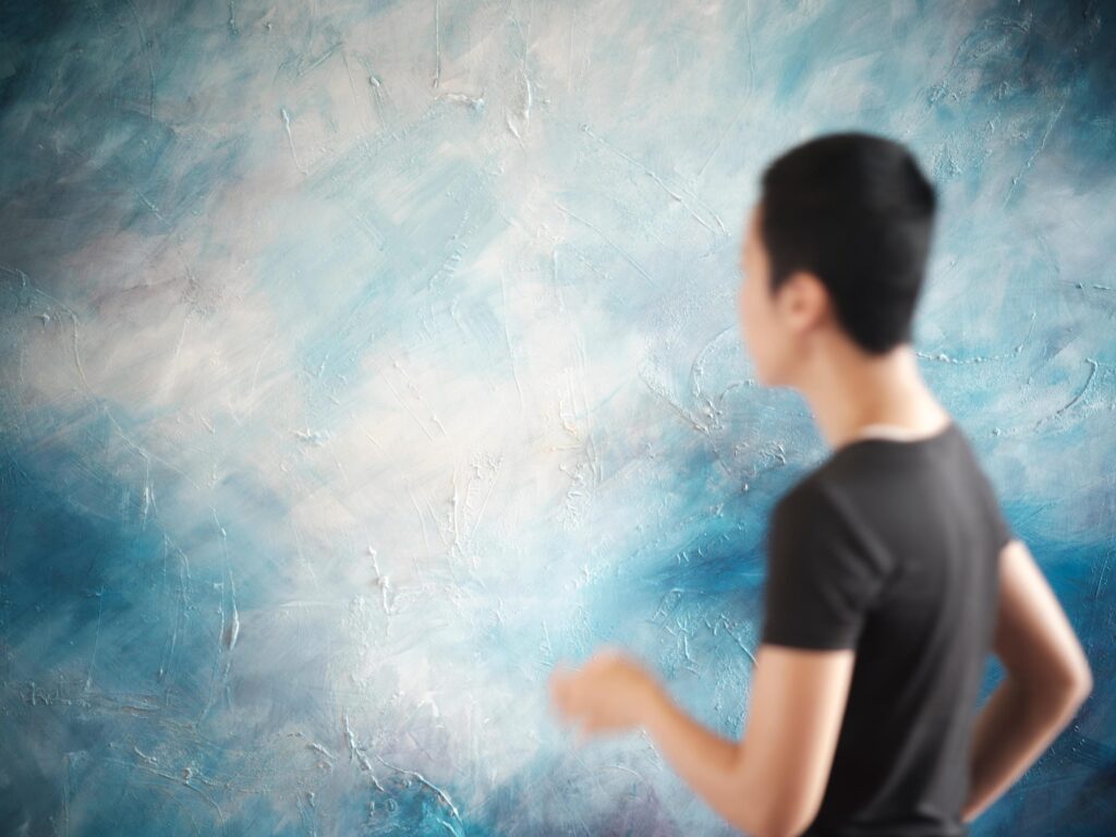 Pare Patcharapa Inchang turning towards a blue-and-white painting in her Chiang Mai studio.