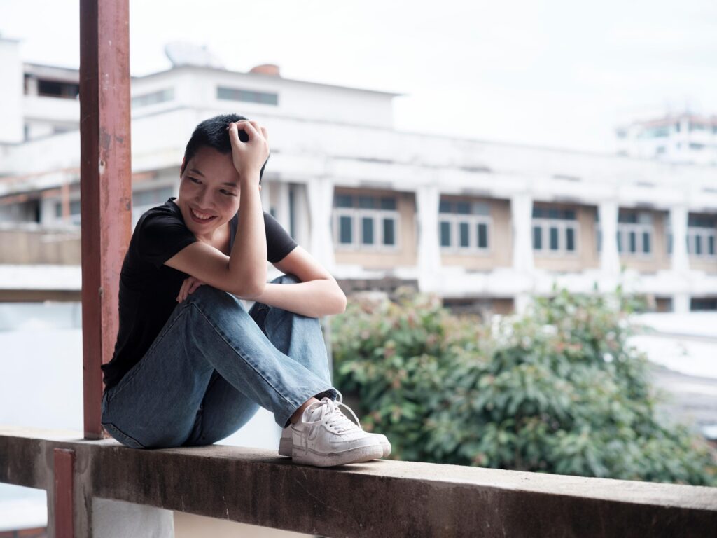Pare Patcharapa Inchang seated on a balcony ledge in Chiang Mai.