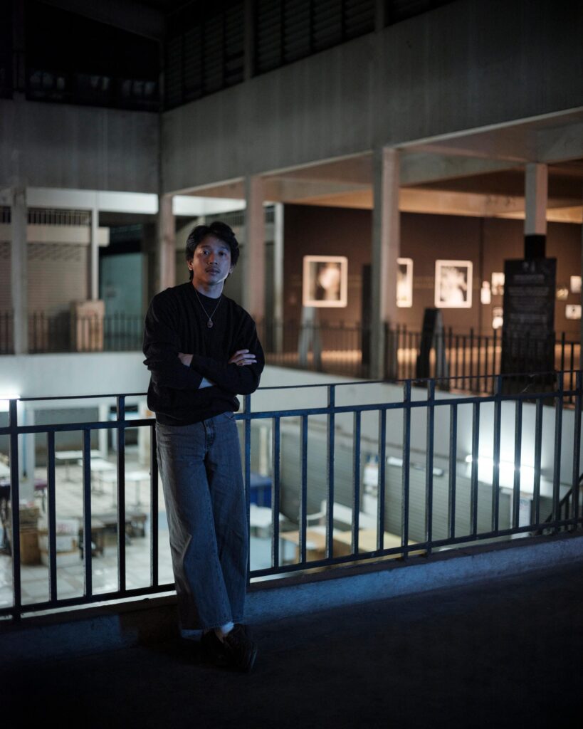 Peerapon Boonthep beside a railing overlooking an exhibition at Artcade Gallery in Phayao.