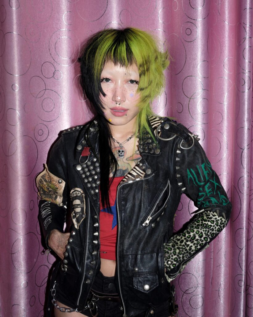 Pemika Wongsurakarn (Sadsadgirl) in a decorated black leather jacket against pink curtains in Samut Sakhon.
