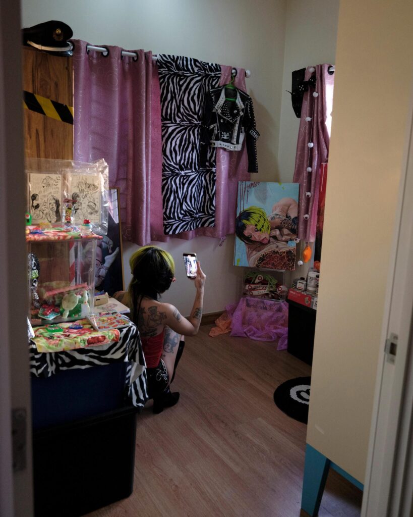 Pemika Wongsurakarn (Sadsadgirl) sitting before a mirror in her art-filled Samut Sakhon room.