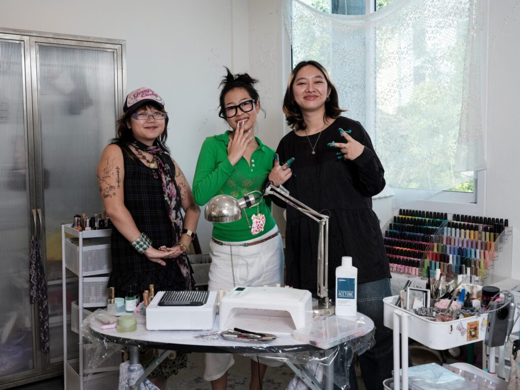 Three Q3Q Community members posing at their Bangkok studio worktable.