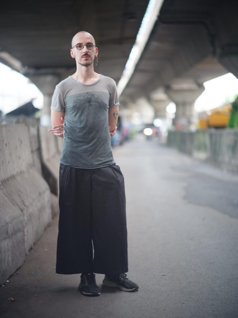 Roman Solodkov (Palindroma) standing beneath an elevated roadway in Bangkok.