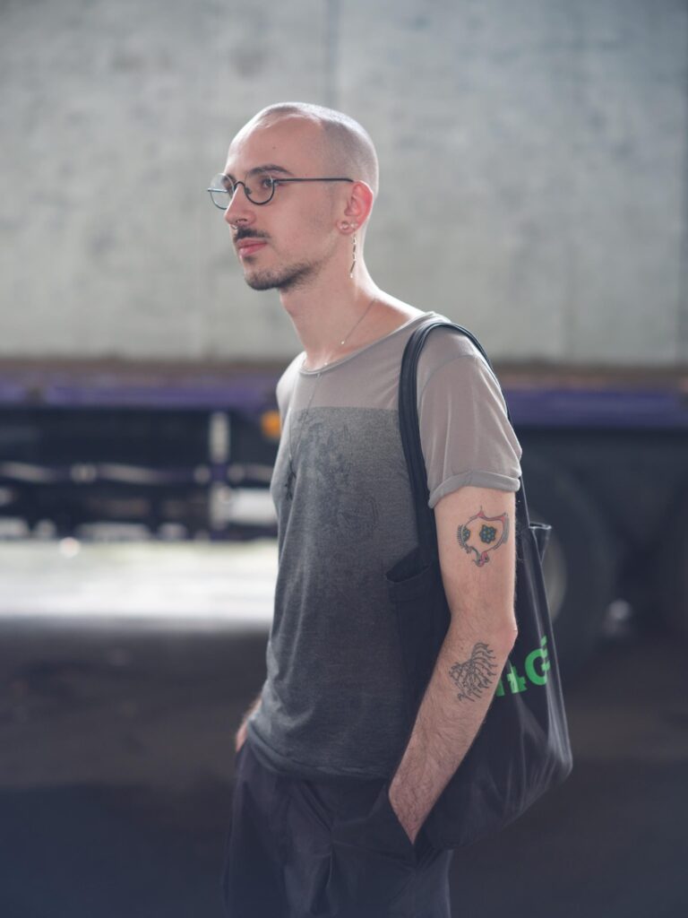 Side portrait of Roman Solodkov (Palindroma) wearing a shoulder bag in Bangkok.