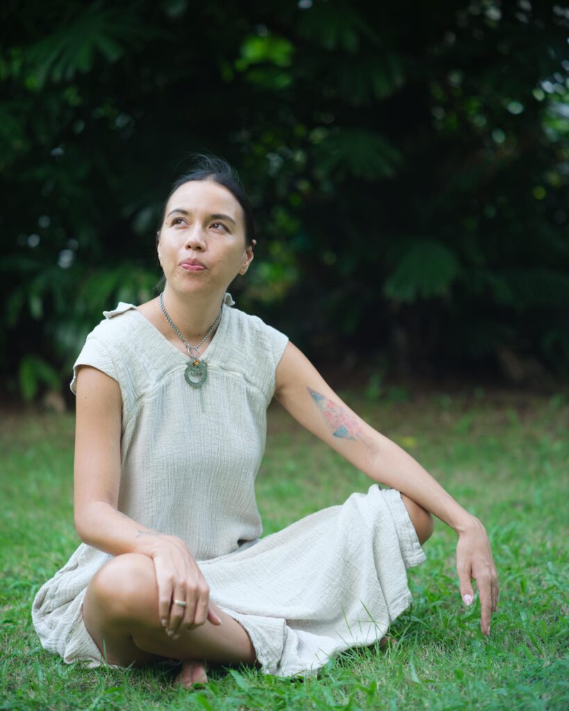 Rosalia Engchuan sitting on a lawn in a pale dress in Bangkok.
