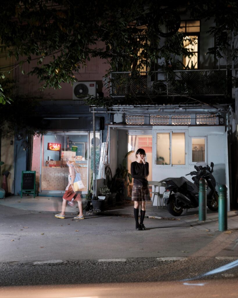 Sandee standing outside her Bangkok studio at night.